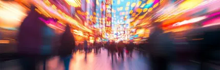 Blurred photo of a vibrant Las Vegas street at night, filled with colorful lights, neon signs, and crowds of people.